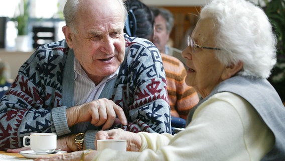 Zwei Senioren sitzen während eines Seniorentreffes beim Mittagessen zusammen am Tisch. © picture-alliance/ ZB Foto: Oliver Killig