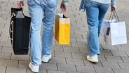 Eine Frau und ein Mann tragen mehrere Einkaufstüten am verkaufsoffenen Sonntag auf der Mönckebergstraße. © picture alliance/dpa Foto: Georg Wendt
