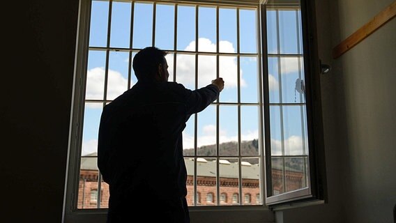 Ein Mann steht in einer Justizvollzugsanstalt vor einem vergitterten Fenster im Block der Sicherungsverwahrten. © dpa Foto: Patrick Seeger
