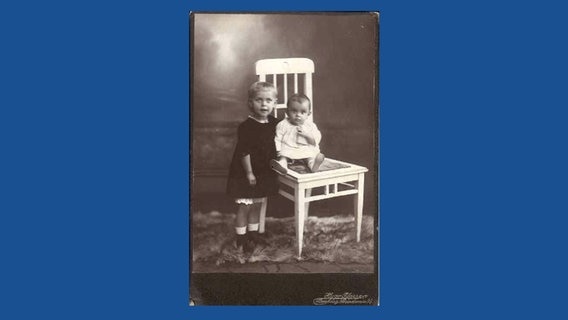 Die beiden Kinder von Carl Christian Silck, Annemarie und Carl-Heinz, posieren für das Foto auf einem Stuhl, um 1920.  