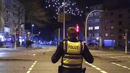 Ein Polizist sichert in der Silvesternacht eine Straße in Hamburg. © TV Newskontor Foto: Screenshot