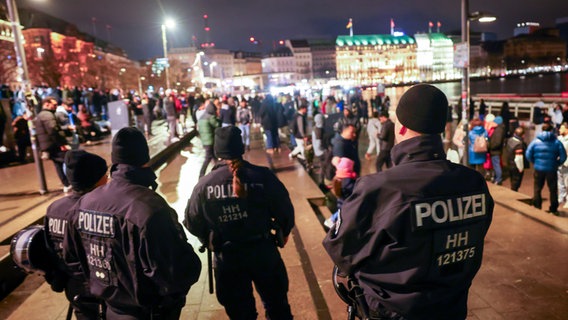Polizeikräfte stehen auf dem Hamburger Jungfernstieg und kontrollieren das Verbot von Feuerwerk an der Binnenalster kurz vor dem Jahreswechsel. © picture alliance/dpa | Christian Charisius Foto: Christian Charisius