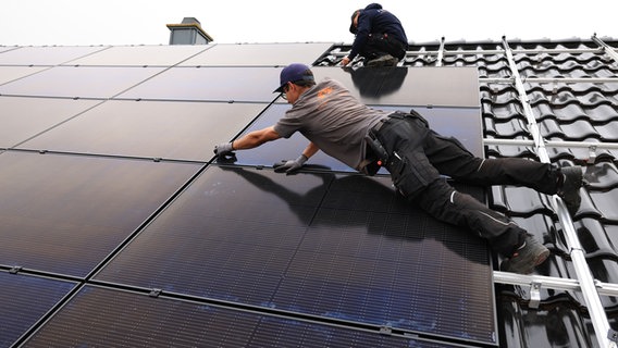 Handwerker montieren auf dem Dach eines Wohnhauses Solarmodule. © picture alliance/dpa | Oliver Berg Foto: Oliver Berg