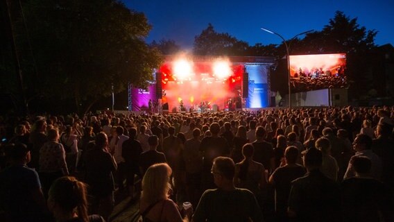 Eine Menschenmenge steht Nachts vor einer hell erleuchteten Bühne © NDR Foto: Axel Herzig