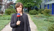 Elke Spanner hält ein Mikrofon. © NDR 