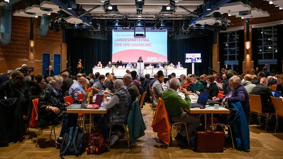 Zahlreiche SPD-Mitglieder sitzen zu Beginn des Landesparteitags im Bürgerhaus Wilhelmsburg. © Jonas Walzberg/dpa 