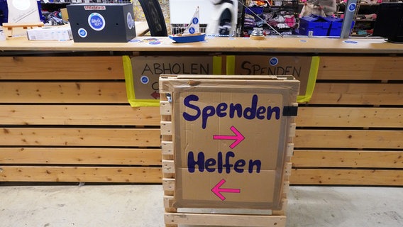 Ein Schild in der Kleiderkammer der Hilfsorganisation Hanseatic Help verweist zum Spenden nach rechts und zum Helfen nach links. © picture alliance/dpa | Marcus Brandt Foto: Marcus Brandt