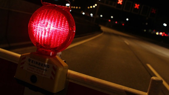 Eine rote Warnlampe steht auf der gesperrten Autobahn 7 in Hamburg. © picture alliance / dpa Foto: Malte Christians