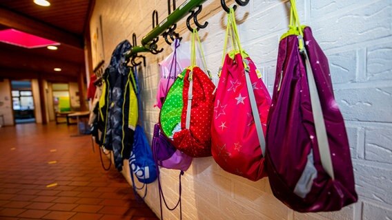 Turnbeutel hängen an einer Garderobenstange in einer Schule. © picture alliance / Inderlied/Kirchner-Media 