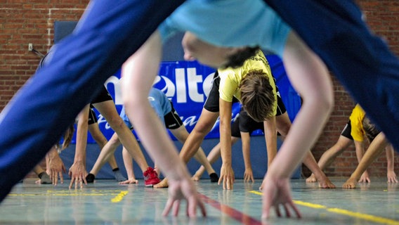 Schüler machen in Hamburg während es Sportunterrichts Aufwärm- und Dehnübungen. © picture alliance / dpa Foto: Markus Scholz
