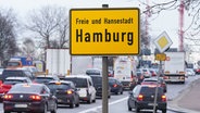 Autos und Lastwagen stehen in Hamburg im Bereich der Elbbrücken im Stau. Im Vordergrund ist ein Ortsschild mit der Aufschrift "Freie und Hansestadt Hamburg" zu sehen. © picture alliance/dpa Foto: Marcus Brandt
