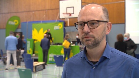 Der Hamburger Grünen-Politiker Till Steffen steht bei einer Kreismitgliederversammlung in einer Sporthalle. © NDR 