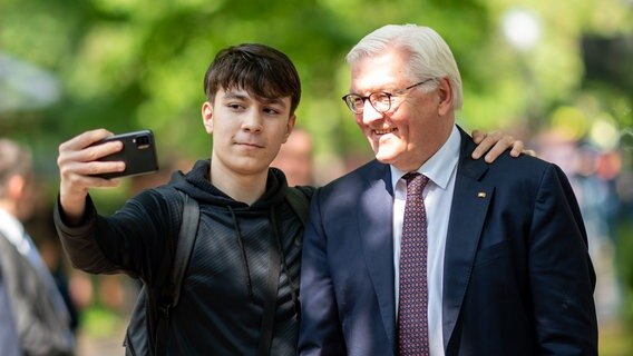 Ein Schüler nimmt mit Bundespräsident Frank-Walter Steinmeier bei einem Besuch des Louise Weiss Gymnasiums ein Selfie auf © picture alliance/dpa | Daniel Reinhardt Foto: Daniel Reinhardt