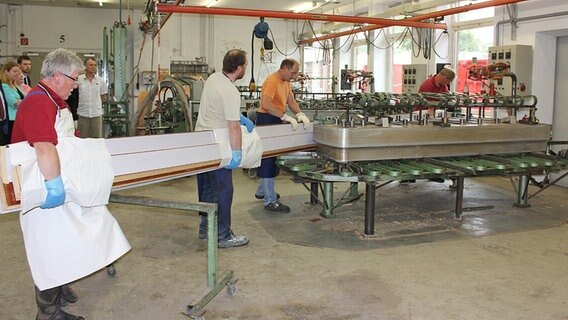 Steinway-Mitarbeiter tragen geleimte Holzplatten zum Biegen © NDR.de Foto: Kristina Festring-Hashem Zadeh, NDR.de
