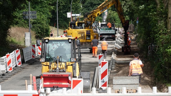 Arbeiter sind auf einer Straßenbaustelle in Hamburg zu sehen. © picture alliance/dpa | Julian Weber Foto: Julian Weber