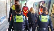 Einsatzkräfte der Polizei begleiten eine Person. © CitynewsTV 