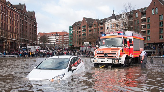 Einsatzkräfte ziehen ein Auto vom überfluteten Fischmarkt. © picture alliance/dpa Foto: Daniel Bockwoldt