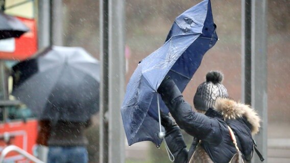 Bei Regen und Sturm sind Passanten an den Landungsbrücken in Hamburg unterwegs © picture alliance / dpa Foto: Bodo Marks