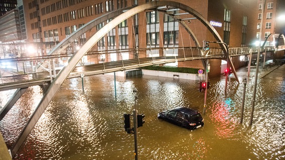 Ein Auto steht in der Speicherstadt, während einer Sturmflut im Hochwasser der Elbe im Wasser. © picture alliance/dpa Foto: Daniel Bockwoldt