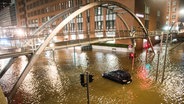 Ein Auto steht in der Speicherstadt, während einer Sturmflut im Hochwasser der Elbe im Wasser. © picture alliance/dpa Foto: Daniel Bockwoldt