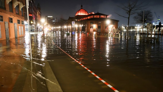 Das Wasser der Elbe wird bei einer Sturmflut auf die Große Elbstraße am Hamburger Fischmarkt gedrückt. © Bodo Marks/dpa 