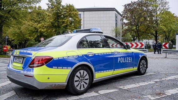 Ein Polizeiauto und mehrere Beamte sichern eine Synagoge in Hamburg.  Foto: Axel Heimken