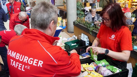 Zwei Mitarbeiter der Hamburger Tafel sortieren Lebensmittelspenden, die in einem Einkaufszentrum gespendet wurden. © picture alliance 