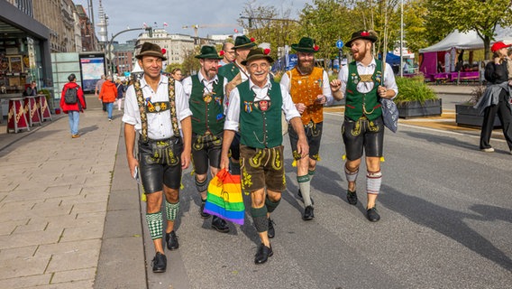 Männer in Trachten gehen während der Feierlichkeiten zum Tag der Deutschen Einheit am Jungfernstieg in Hamburg entlang. © NDR Foto: Axel Herzig