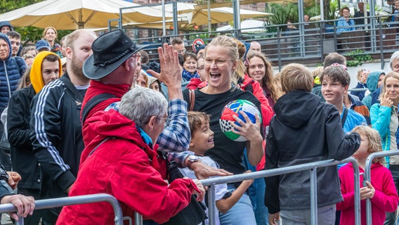 Besucherinnen und Besucher vor der NDR Bühne freuen sich über einen gefangenen EM-Spielball. © NDR Foto: Axel Herzig