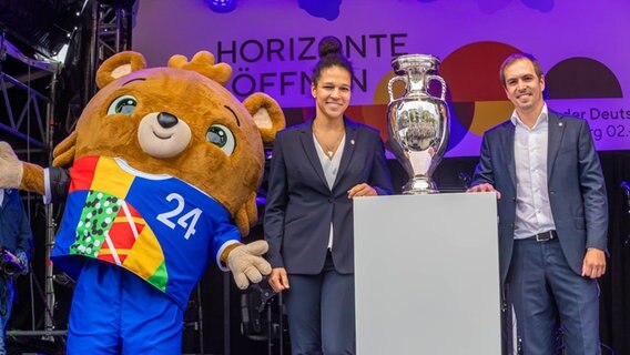 Turnierdirektor Philipp Lahm, Turnierbotschafterin Célia Šašić und das EM-Maskottchen zusammen mit dem Pokale der Fußball-Europameisterschaft auf der NDR Bühne. © NDR Foto: Axel Herzig