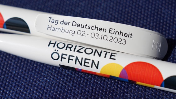 Zwei Kugelschreiber mit einer "Tag der Deutschen Einheit" Aufschrift. © picture alliance/dpa | Marcus Brandt Foto: picture alliance/dpa