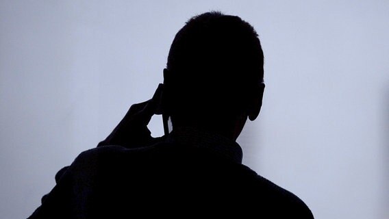 Ein Mann telefoniert an einem Fenster. © picture alliance/dpa Foto: Sebastian Gollnow