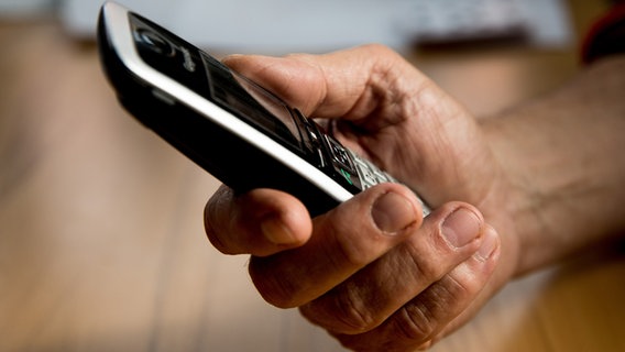 Eine ältere Person hält ein Telefon in der Hand. © picture alliance / Fotostand Foto: K. Schmitt