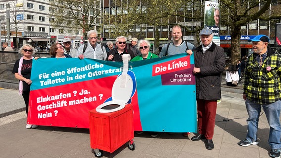 Mehrere Personen halten ein Transparent für eine öffentliche Toillette in der Osterstraße. © NDR Foto: Ingmar Schmidt