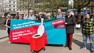 Mehrere Personen halten ein Transparent für eine öffentliche Toillette in der Osterstraße. © NDR Foto: Ingmar Schmidt