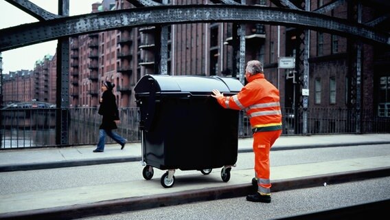 Hans-Dieter Braatz, Fahrer bei der Müllabfuhr Hamburg, schiebt eine zur Lochkamera umgebaute Mülltonne. © dpa-Bildfunk Foto: Mirko Derpmann
