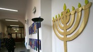 In der Hamburger Talmud-Tora-Schule hängt ein siebenarmiger Leuchter an der Wand © dpa Foto: Jens Ressing