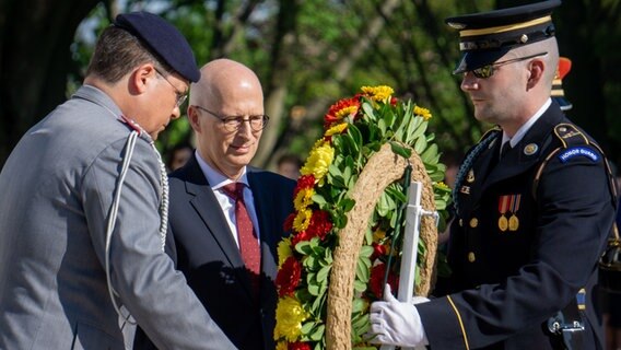 Peter Tschentscher (Mitte) neben zwei Soldaten bei einer Kranzniederlegung auf dem Soldatenfriedhof in Arlington. © Senatskanzlei 