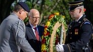 Peter Tschentscher (Mitte) neben zwei Soldaten bei einer Kranzniederlegung auf dem Soldatenfriedhof in Arlington. © Senatskanzlei 