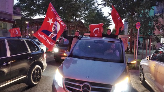 Anhänger des türkischen Präsidenten Erdogan fahren mit Türkeifahnen nach den ersten Hochrechnungen zur türkischen Parlaments- und Präsidentenwahl durch den Hamburger Stadtteil Wilhelmsburg. © picture alliance / dpa Foto: Kay Nietfeld