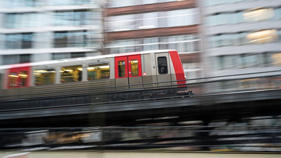 Eine Bahn der U-Bahn-Linie 3 fährt zwischen den Haltestellen Rathausmarkt und Rödingsmarkt auf einer Rampe an die Oberfläche. © picture alliance / dpa Foto: Daniel Reinhardt