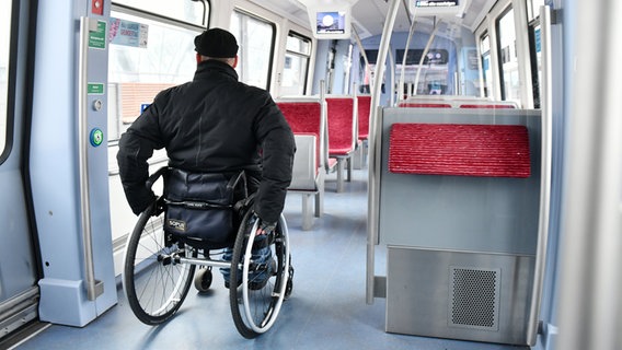 Ein Mann im Rollstuhl fährt durch eine Hamburger U-Bahn. © Frank May 