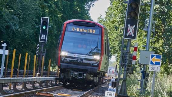 Eine U-Bahn mit der Aufschrift "U-Bahn 100" fährt zur ersten Fahrt mit automatisierter U-Bahn auf der Teststrecke im Hamburger Stadtteil Farmsen-Berne. © picture alliance / dpa Foto: Georg Wendt