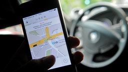 Auf einem Smartphone ist die App des Fahrdienstvermittlers Uber zu sehen © dpa Foto: Britta Pedersen
