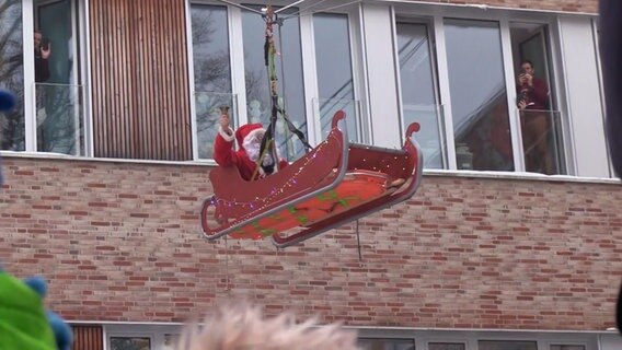 Ein Nikolaus sitzt in einem Schlitten, der an einem Seil hängt. © Nonstop News Foto: Screenshot