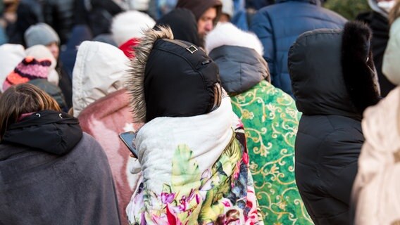 Ukrainische Flüchtlinge warten in Decken gehüllt vor dem Amt für Migration in der Hammer Straße in Hamburg auf ihre Registrierung. © dpa Foto: Daniel Bockwoldt
