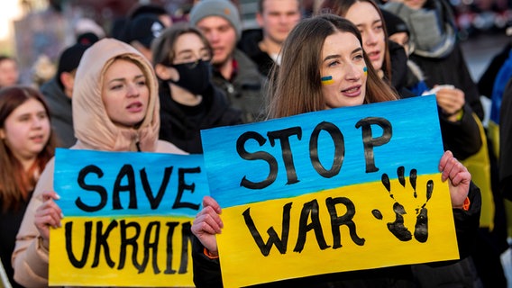 Teilnehmerinnen einer Demonstration gegen den Krieg in der Ukraine halten in hamburg Plakate mit der Aufschrift "Save Ukraine" und "Stop war". © picture alliance/dpa Foto: Daniel Bockwoldt