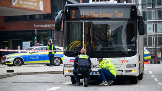 Ein Polizist und ein Sachverständiger ermitteln an einem Unfallort in der Hamburger Hafencity. © dpa Foto: Jonas Walzberg