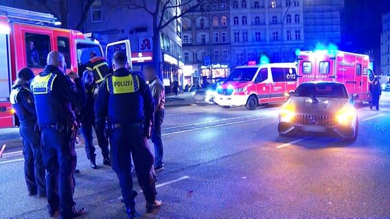 Ein Mercedes steht nach einem Unfall im Hamburger Stadtteil St. Georg auf der Straße. Im Vordergrund sind Rettungskräfte zu sehen. © TV Newskontor 