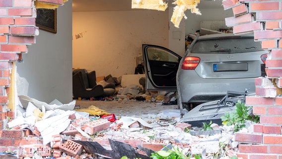 Im Wohnzimmer eines Hauses in Lurup steht nach einem Unfall ein Auto. © picture alliance/dpa Foto: Jonas Walzberg